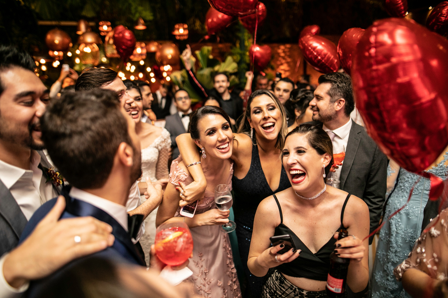 Groom and wedding guests laughing during party